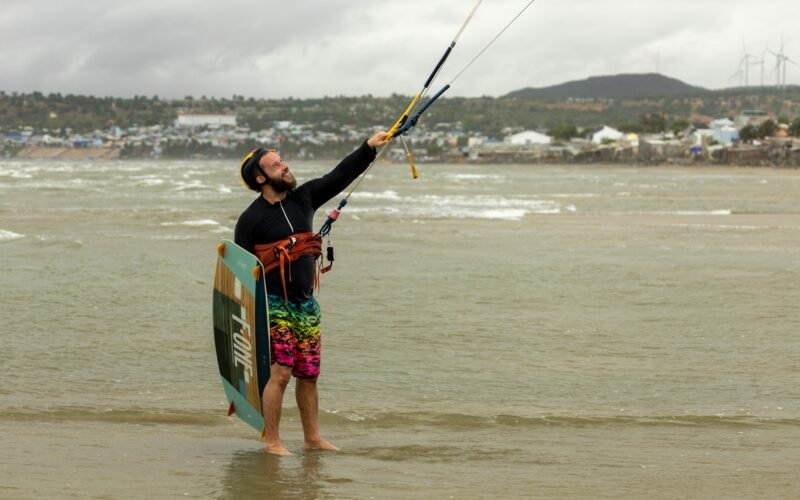 Un kitesurfeur tenant sa barre et ses lignes en position de navigation