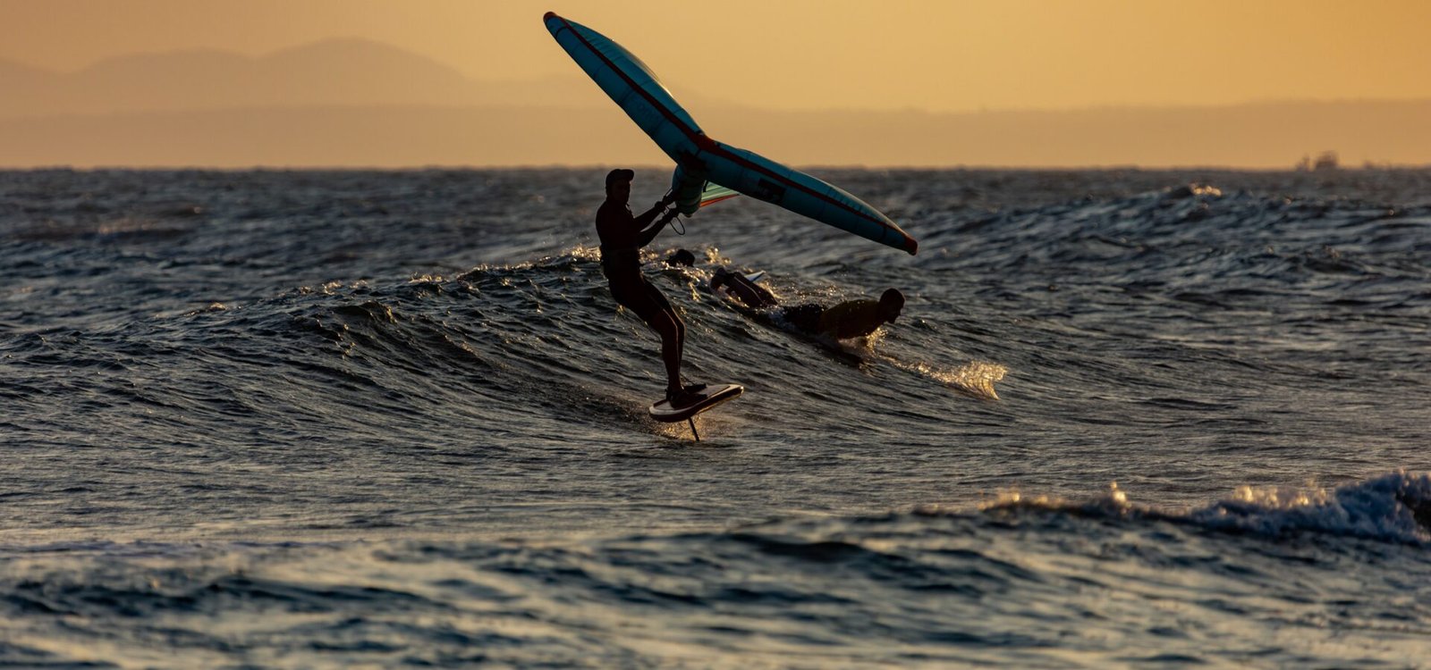 Une aile de kitesurf déployée dans le ciel au-dessus de la mer