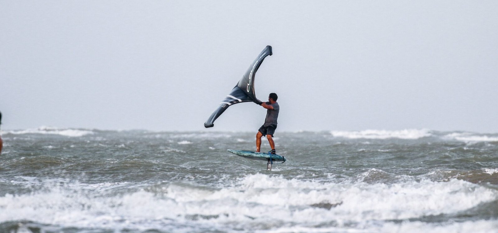 Un rider de wing foil en pleine chute dans l'eau
