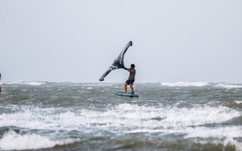 Un rider de wing foil en pleine chute dans l'eau