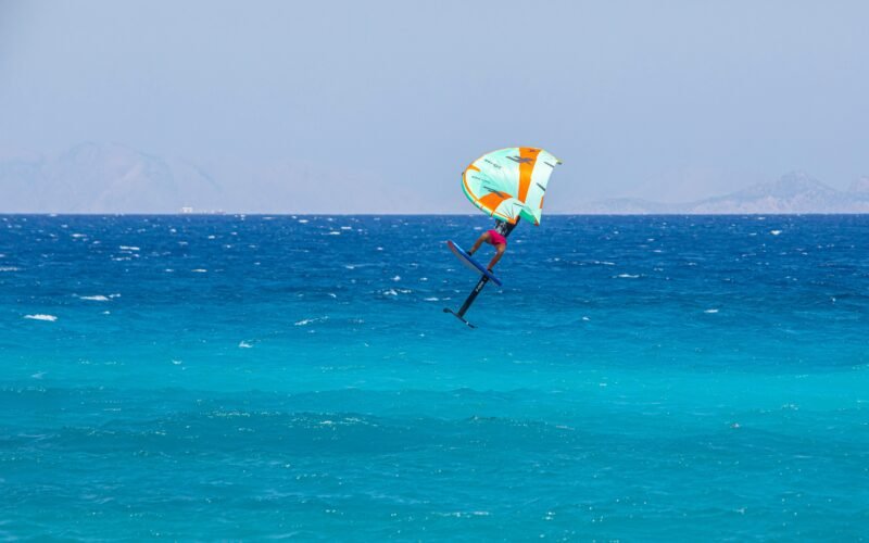 Un rider de foil en plein vol au-dessus de l'eau turquoise